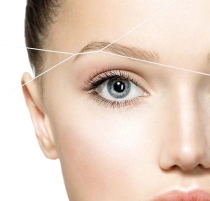 Close-up of precise eyebrow threading for defined brow shapes